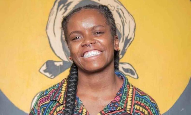 Suellen Sampaio, mulher negra, sorri olhando para a cmera 