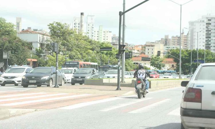 vrios carros na rua da cidade. Tambm pode ser visto uma moto  