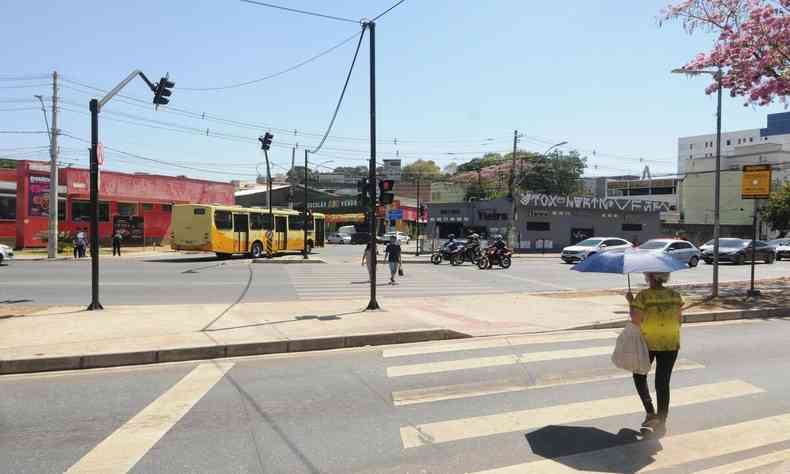 pessoal se protegendo do sol com sombrinha 