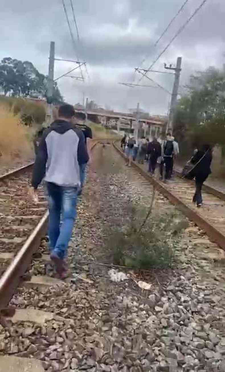 pessoas caminhando sobre trilhos do metr