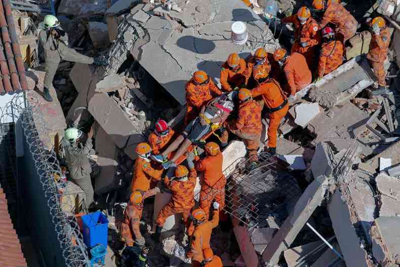 Bombeiros resgatam um sobrevivente entre os destroos do prdio residencial de sete andares que desabou em Fortaleza(foto: AFP / Dirio do Nordeste / Thiago GADELHA)