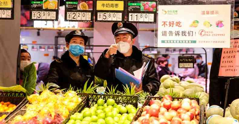 Agentes usam mscaras em Huaibei, na provncia de Anhui, Leste da China, onde os casos de coronavrus voltaram a crescer(foto: STR/AFP )