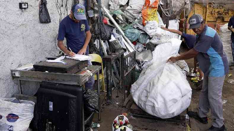 Elias colocando reciclagem que recolheu em cima de balana