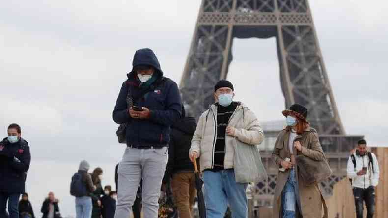 Pessoas, usando mscaras, caminham pela praa do Trocadero, perto da Torre Eiffel, em Paris.