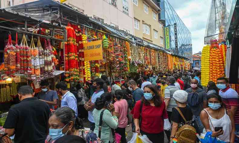 Pessoas de mscara andando em um feira de Cingapura 