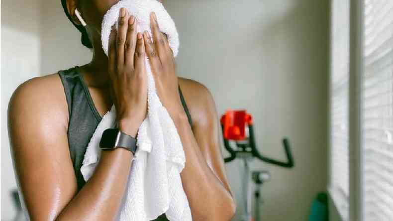 mulher limpando o rostos com toalha