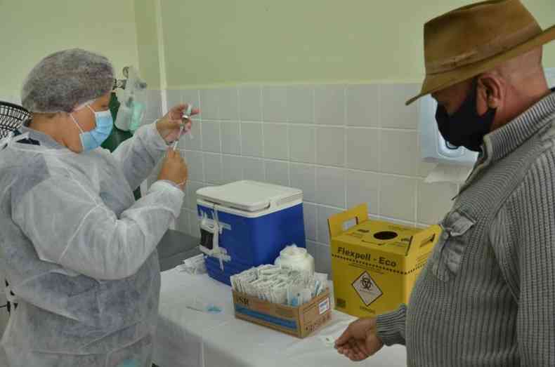 Profissional da sade se prepara para aplicar a vacina em morador de Betim