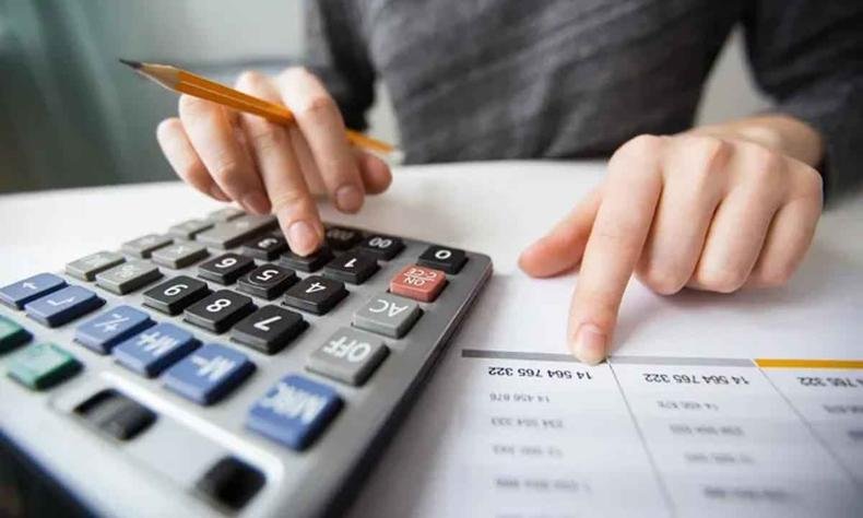 M�os mexendo em uma calculadora
