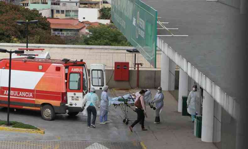 Paciente sendo transportado de ambulância para hospital, acompanhado por equipe de saúde. 