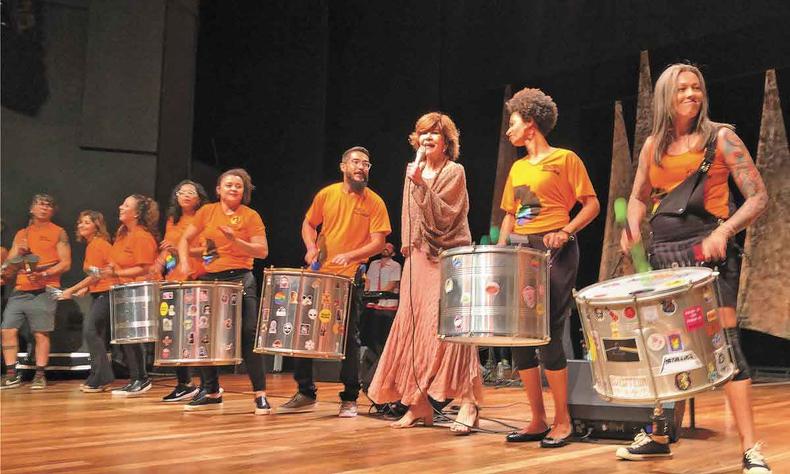 Sandra Pêra recebeu no palco integrantes do bloco Volta, Belchior, no show dedicado ao repertório do cantor e compositor cearense(foto: Helvécio Carlos EM/D.A Press) Sandra Pêra canta com o microfone na mão, ao lado de percussionistas do bloco Volta, Belchior