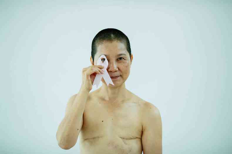 Mulher operada de cncer de mama segura o smbolo da campanha de preveno