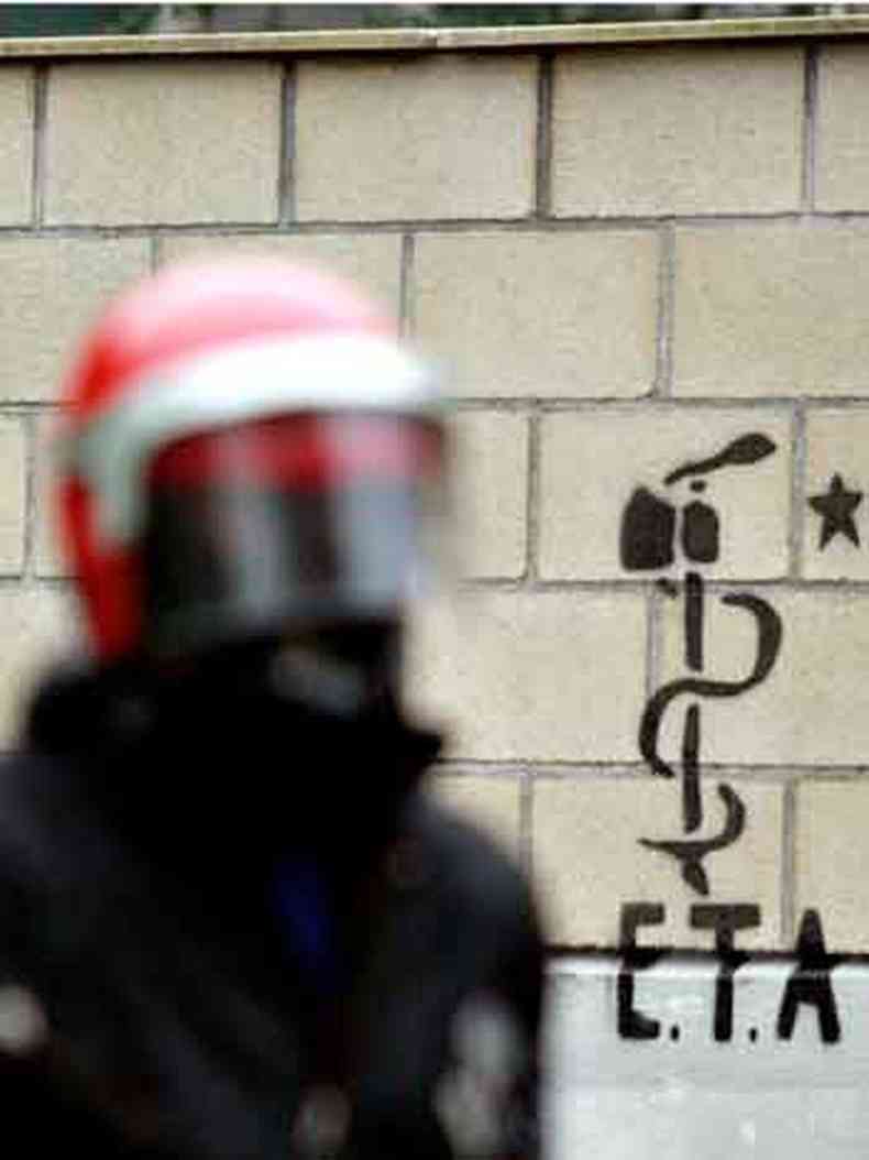 Policial passa em frente a inscrio do ETA em prdio em Lizartza, durante manifestao de nacionalistas bascos contra o prefeito local, em 2007 (foto: Vincent West/Reuters)