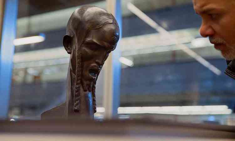 Homem observa a escultura 'Cabeça de Cristo', de Brecheret
