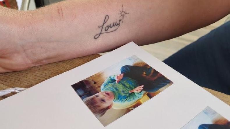 Foto de Louis em lbum de foto e uma tatuagem do seu nome na parte inferior do brao de sua me