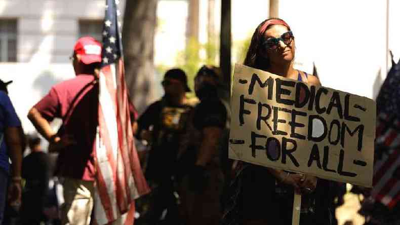 Mulher em protesto antivacina segurando cartaz em que se l 'liberdade mdica para todos'