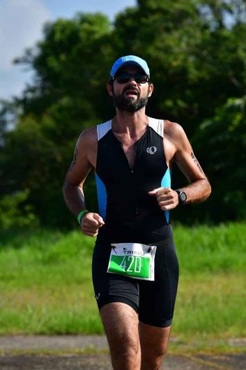 Homem atleta correndo em pista com culos e bon