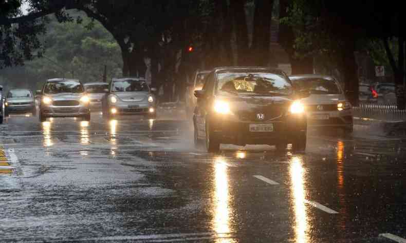 Carros trafegando em dia chuvoso na capital