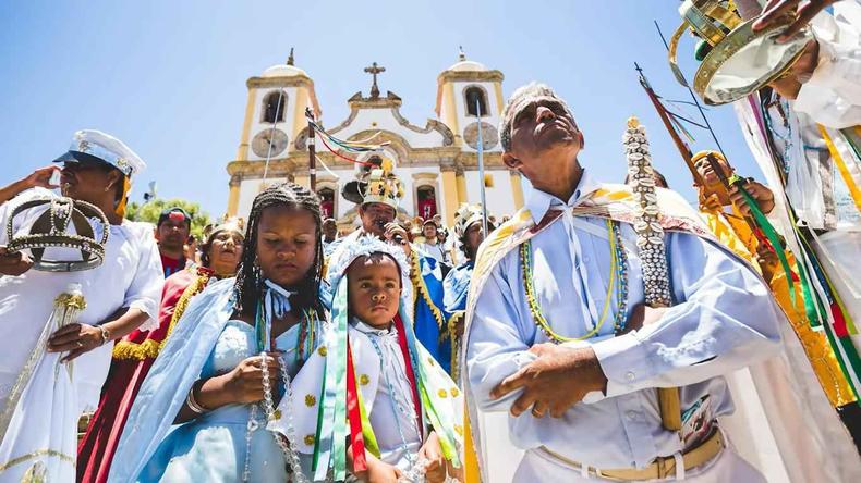 Integrantes da Guarda de Congo diante de igreja em Ouro Preto