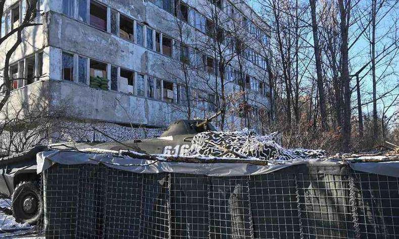 Agência nuclear ucraniana afirmou que sensores registraram aumento de radiação em Chernobyl após tropas russas tomarem área(foto: Sergei Supinsky / AFP) Tanque de guerra em frente a um prédio abandonado em Chernobyl