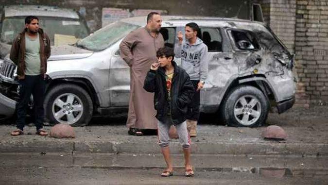 Iraquianos inspecionam estrago causado por carro-bomba em Karrada, na regi�o central de Bagd�. Comunidades xiitas s�o os principais alvos dos ataques terroristas(foto: AHMAD AL-RUBAYE / AFP)