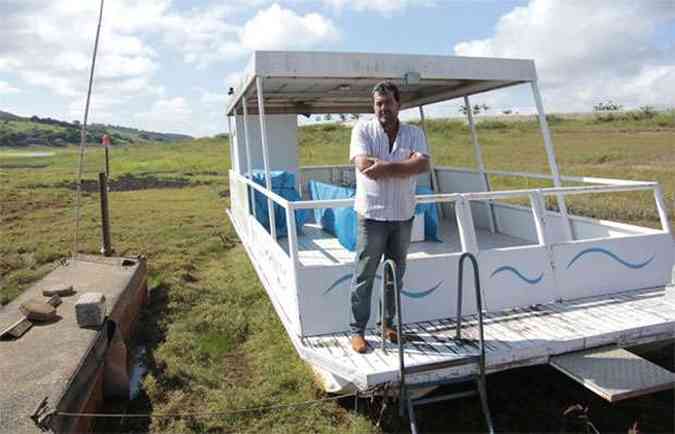 Carlos Moises, dono da Pousada Pontal do Lago, em Carmo Do Rio Claro, e sua escuna encalhada no lago(foto: Sergio Amzalak/ESP. EM/D. A Press)
