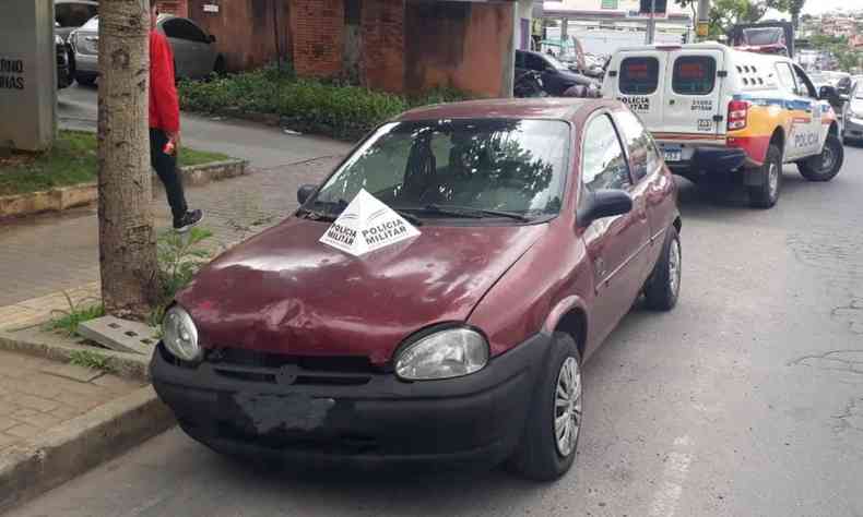 GM Corsa vermelho com um marcador da PMMG