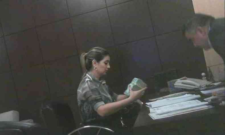 Luciane Bezerra foi flagrada colocando dinheiro na bolsa(foto: Reproduo)
