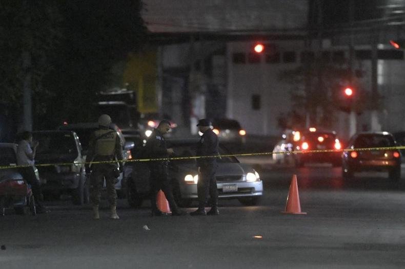 País enfrenta onda de crimes atribuídos a guerra de gangues(foto: MARVIN RECINOS / AFP) policial vigia carro onde corpo foi encontrado em mais um crime no país