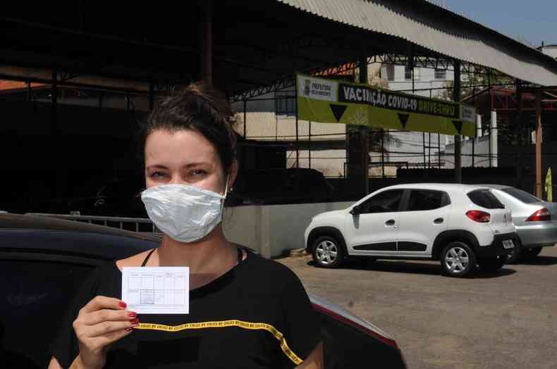 Recm vacinada contra a COVID, mulher exibe carto de vacinao
