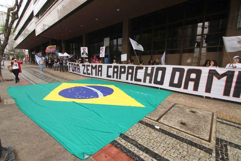 Manifestantes em frente ao Ministrio Pblico com uma bandeira do Brasil no cho