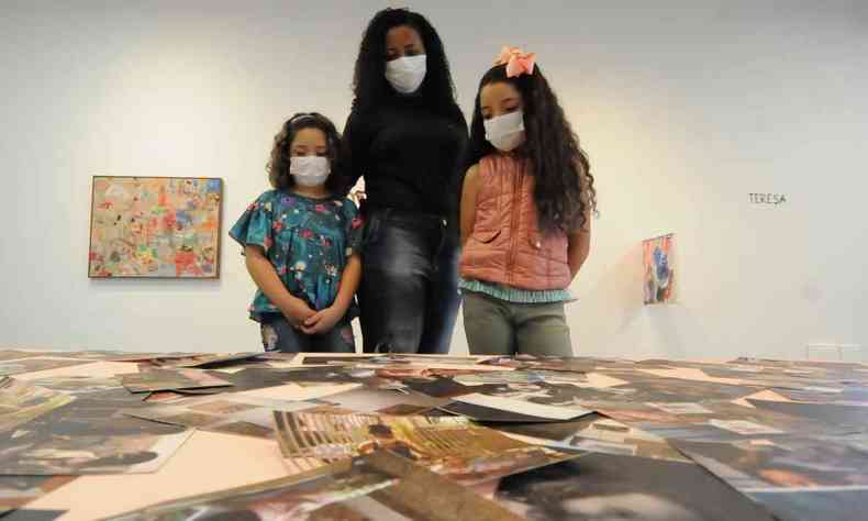 mulher e duas crianas observa obra no museu memorial vale, em bh