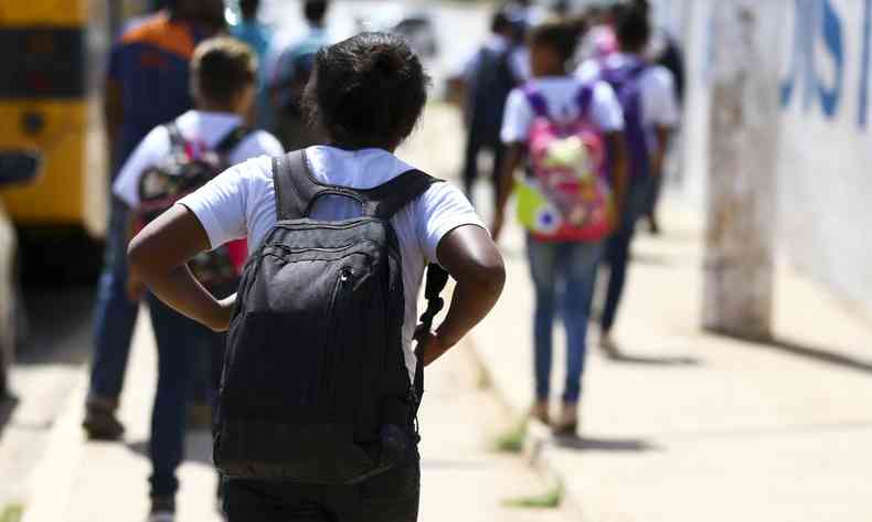 Jovens com mochila a caminho de uma escola