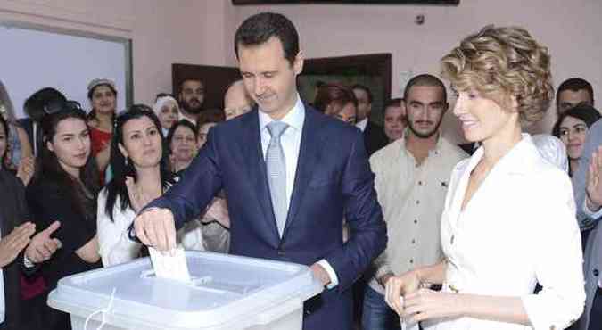 Presidente srio Bashar al-Assad deposita voto em urna na presena de sua esposa Asma(foto: SANA/REUTERS)