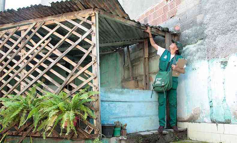 Agente de Controle de Endemias, da SMS/Ipatinga, observa o telhado para ver se h gua acumulada, ambiente propcio para a multiplicao do mosquito Aedes Aegypt(foto: Divulgao PMI)
