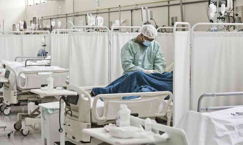Paciente  acomanhado por profissional de sade em leito hospitalar