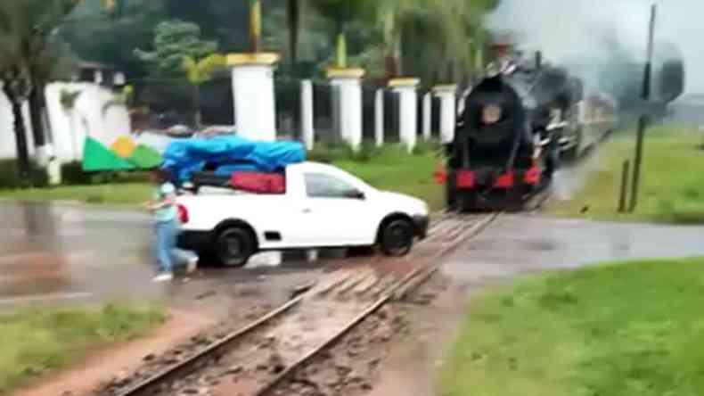 Imagem retirada do vdeo mostra o trem avanando e a caminhonete branca carregada parada sobre os trilhos