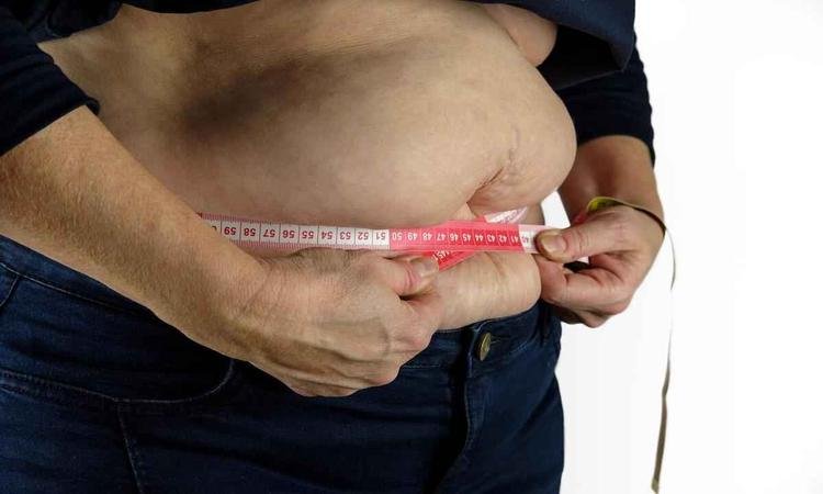 Uma fita m�trica em volta da regi�o da barriga