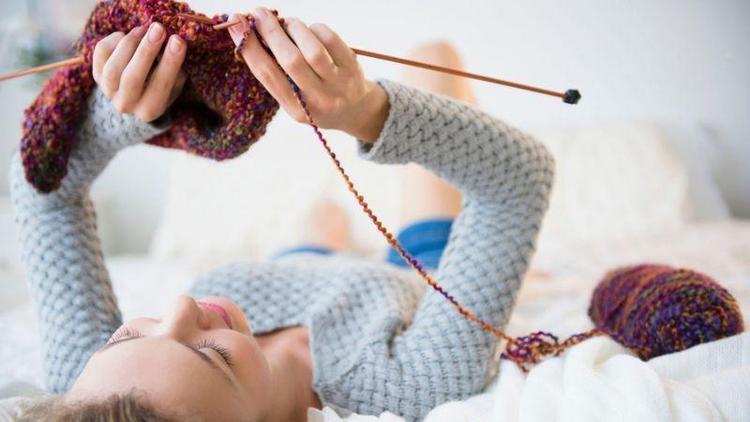 Mulher fazendo tric deitada na cama