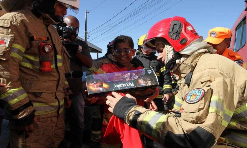 Caio recendo presentes do Corpo de Bombeiros