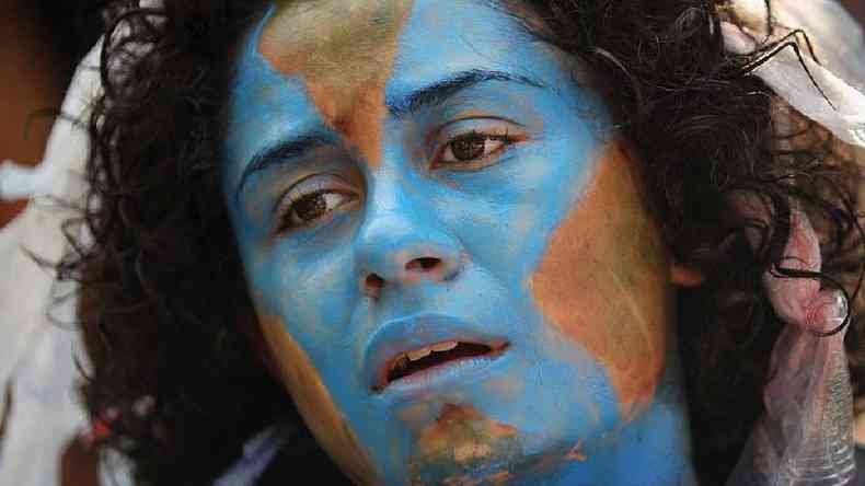 Manifestante com o rosto pintado de planeta Terra durante a conferncia mundial do clima Rio + 20 em junho de 2012