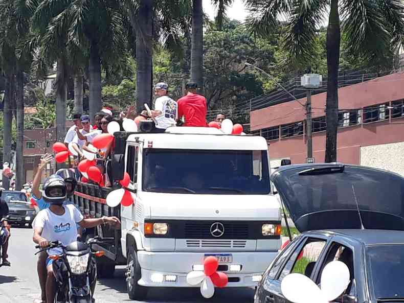 Caminho com vrias pessoas vestidas de Papai Noel