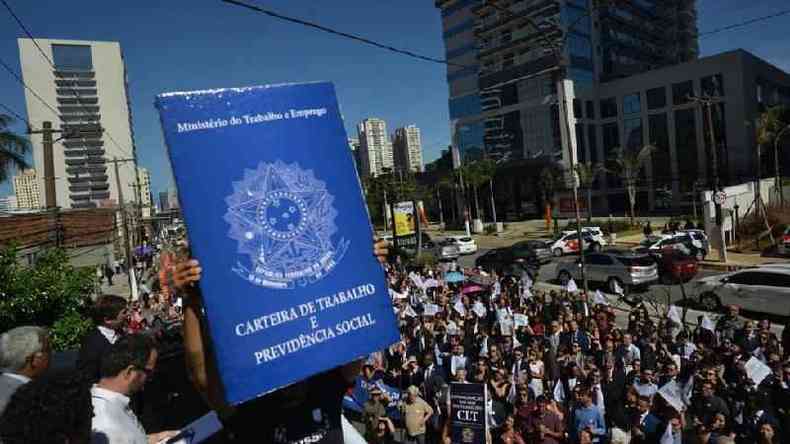 Manifestantes seguram uma carteira de trabalho gigante em protesto contra a possvel extino da Justia do Trabalho (So Paulo, janeiro de 2019)