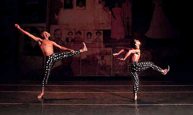dois bailarinos saltam com as pernas separadas em parabelo 