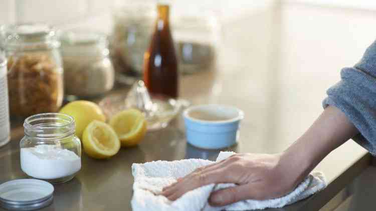 Mo de mulher limpando bancada da cozinha com pano