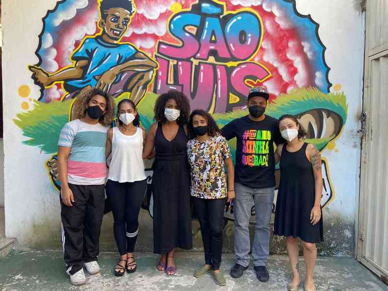 Organizadores do projeto abraados de frente a um grafite na unidade Casa de Semiliberdade So Lus