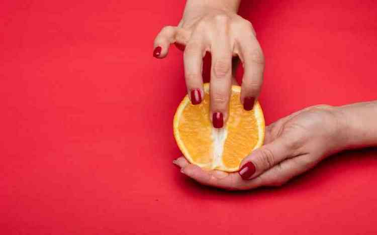 Mulher tocando laranja