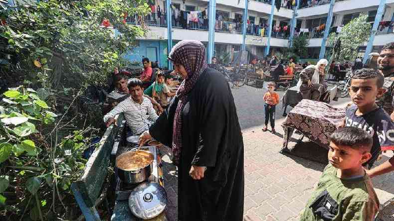 Mulher cozinha para refugiados em escola da ONU em Khan Younis