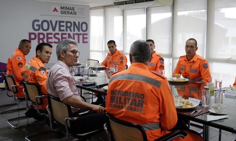 Militares do corpo de bombeiro sentados na mesa com Zema, governador do Estado.