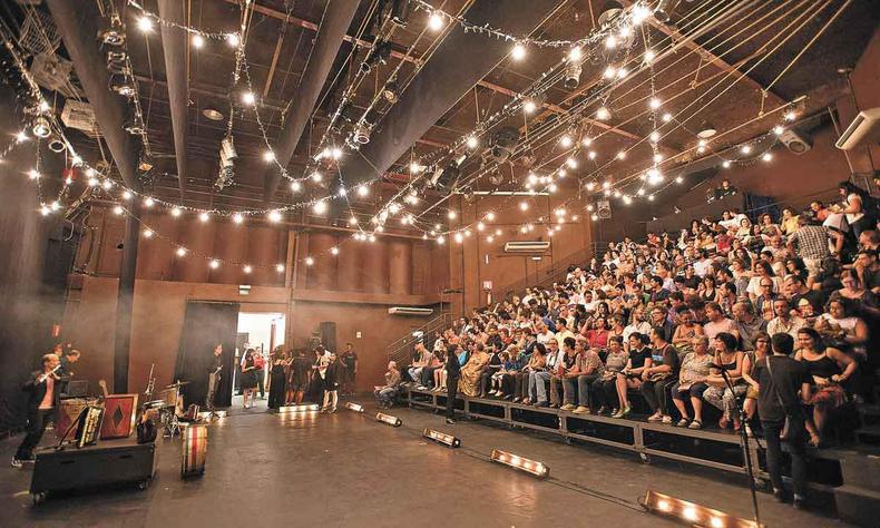 Foto mostra atores, no nvel do cho, e a plateia na arquibancada do Galpo Cine Horto, em BH 