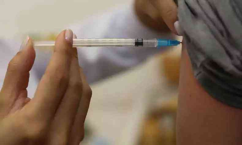 Profissional da saúde aplicando a vacina contra a gripe